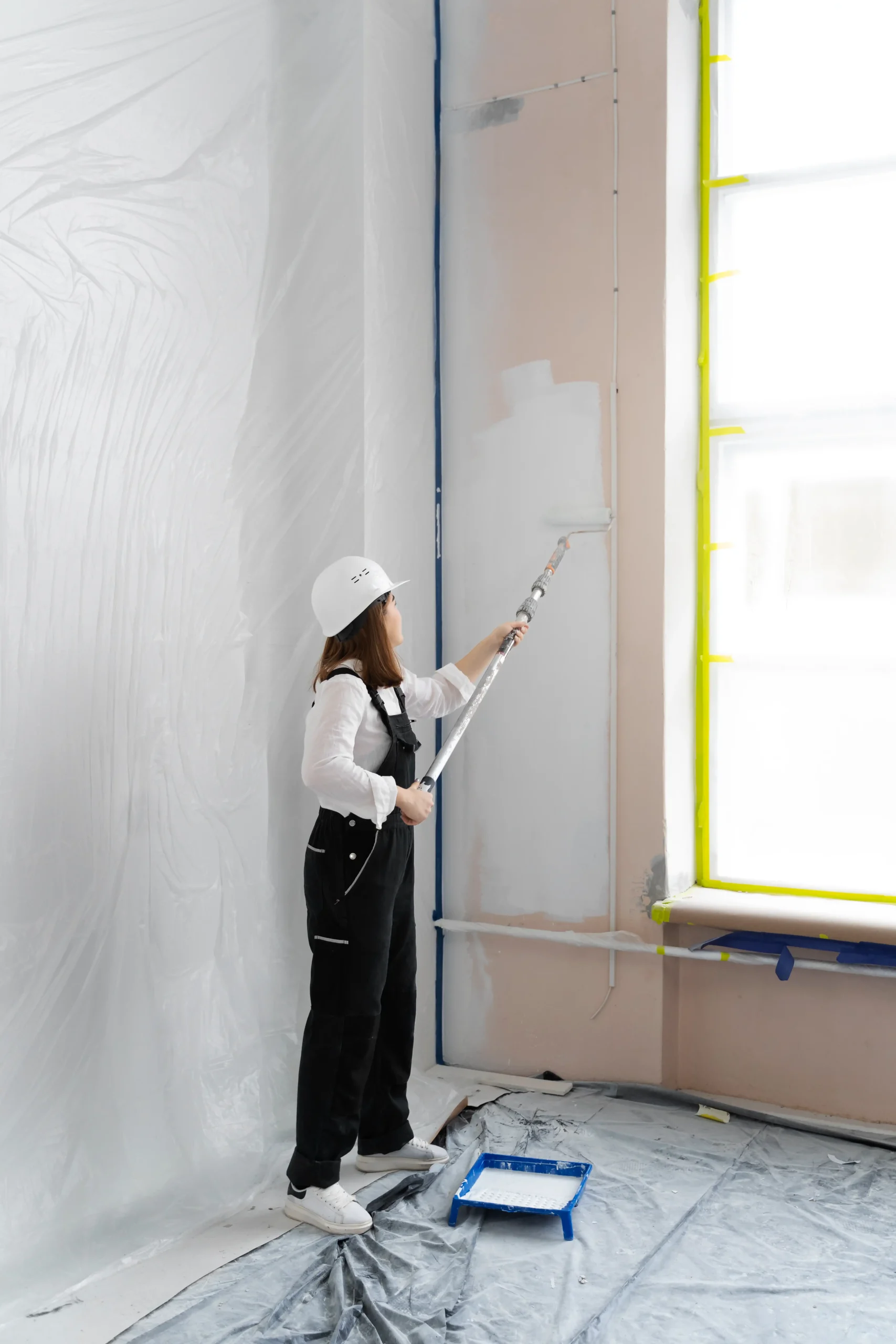 femme qui peint un mur au rouleau